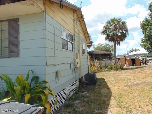 view of side of property featuring a lawn and cooling unit