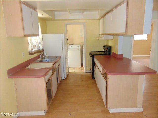 kitchen featuring black electric range oven, washer / clothes dryer, light wood-style floors, a sink, and extractor fan