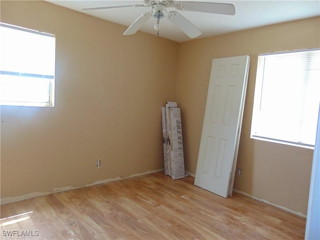 empty room with light wood-style flooring, ceiling fan, and baseboards