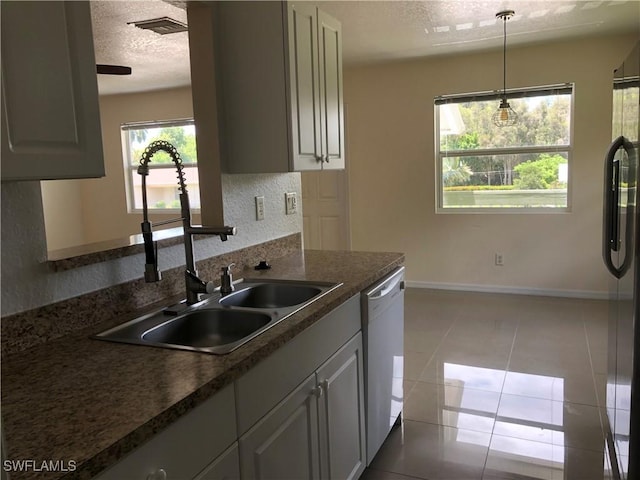 5615 Birdsong Ln, Bokeelia, FL 33922 - kitchen featuring a sink, white dishwasher, a textured ceiling, baseboards, and dark countertops