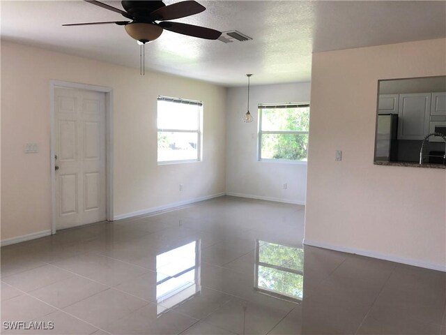 5615 Birdsong Ln, Bokeelia, FL 33922 - spare room featuring ceiling fan, light tile patterned floors, baseboards, a sink, and a textured ceiling