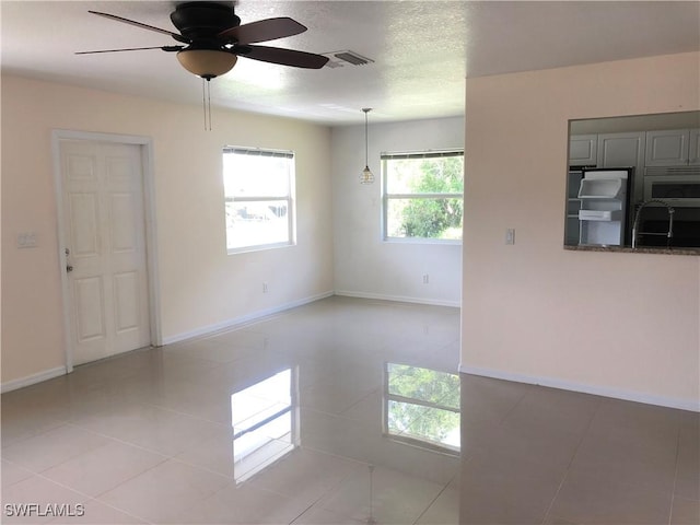 5615 Birdsong Ln, Bokeelia, FL 33922 - spare room with ceiling fan, light tile patterned floors, baseboards, and a textured ceiling