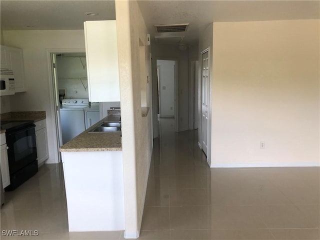 5615 Birdsong Ln, Bokeelia, FL 33922 - corridor with washing machine and dryer, light tile patterned flooring, a sink, and baseboards