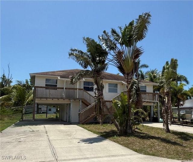5615 Birdsong Ln, Bokeelia, FL 33922 - beach home featuring a carport, stairway, and concrete driveway