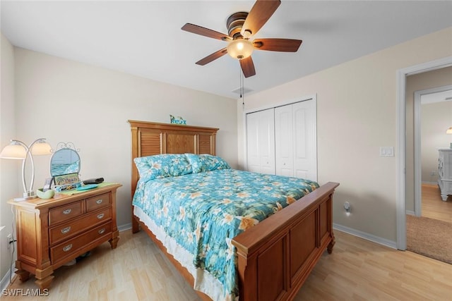bedroom featuring a closet, light wood-type flooring, baseboards, and a ceiling fan