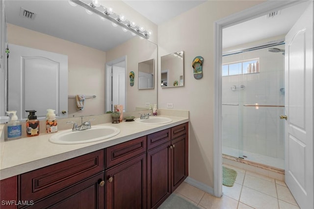 bathroom with a stall shower, tile patterned floors, and double vanity