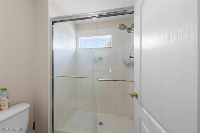 bathroom with a shower stall and toilet