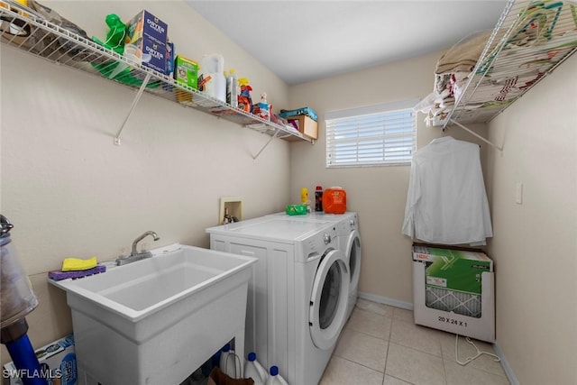 laundry room with washing machine and dryer, heating unit, light tile patterned flooring, and baseboards