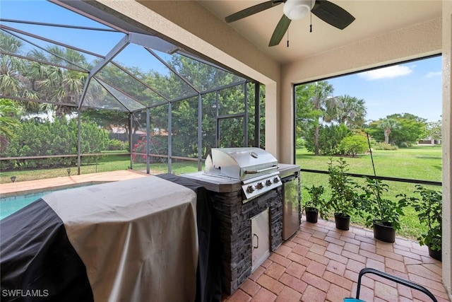 view of patio featuring grilling area, exterior kitchen, a ceiling fan, and a lanai
