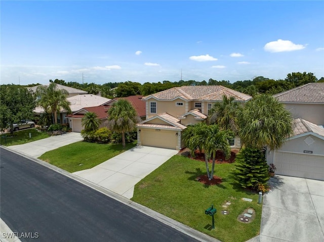 mediterranean / spanish home with driveway, a garage, a front yard, and a residential view