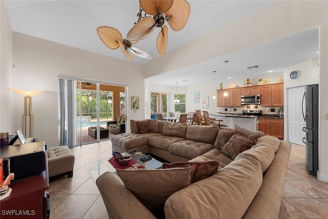living area featuring light tile patterned flooring, a ceiling fan, and plenty of natural light