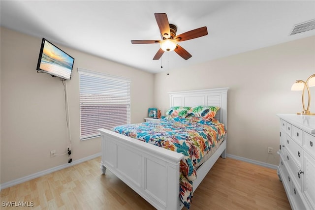 bedroom with light wood-style flooring, baseboards, and ceiling fan