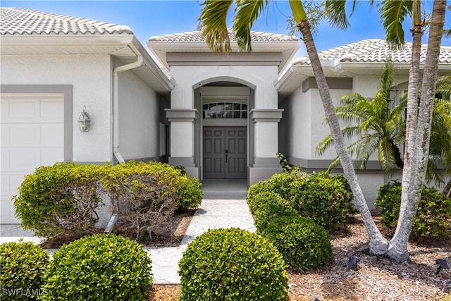 4081 Marianne Key Rd, Punta Gorda, FL 33955 - doorway to property featuring a tile roof, an attached garage, and stucco siding