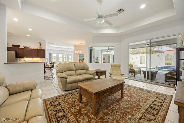 4081 Marianne Key Rd, Punta Gorda, FL 33955 - living room with ceiling fan, light tile patterned flooring, a tray ceiling, recessed lighting, and a chandelier