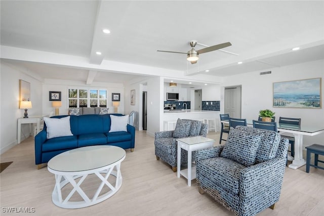 living room featuring beam ceiling, light wood-style floors, a ceiling fan, recessed lighting, and baseboards