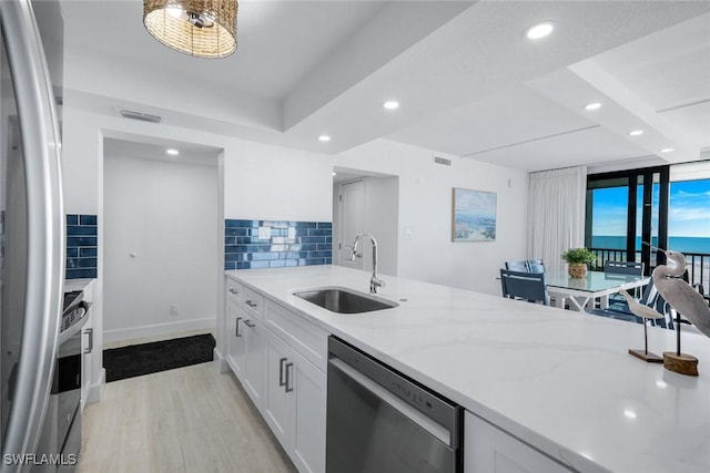 kitchen with appliances with stainless steel finishes, a sink, recessed lighting, light wood-style flooring, and white cabinets