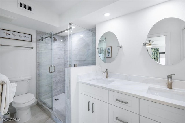 full bath featuring toilet, a stall shower, double vanity, and recessed lighting