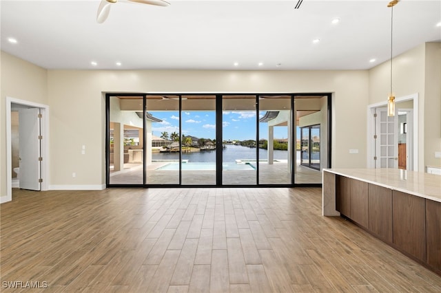 3413 NW 9th Ter, Cape Coral, FL 33993 - unfurnished living room featuring wood finished floors, healthy amount of natural light, recessed lighting, ceiling fan, and baseboards