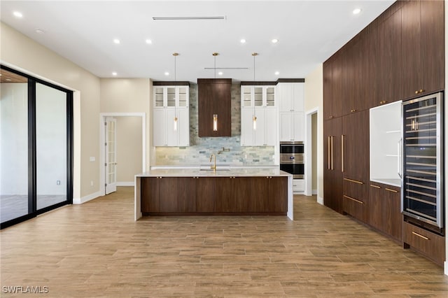 3413 NW 9th Ter, Cape Coral, FL 33993 - kitchen featuring beverage cooler, backsplash, light wood-style floors, white cabinets, and recessed lighting