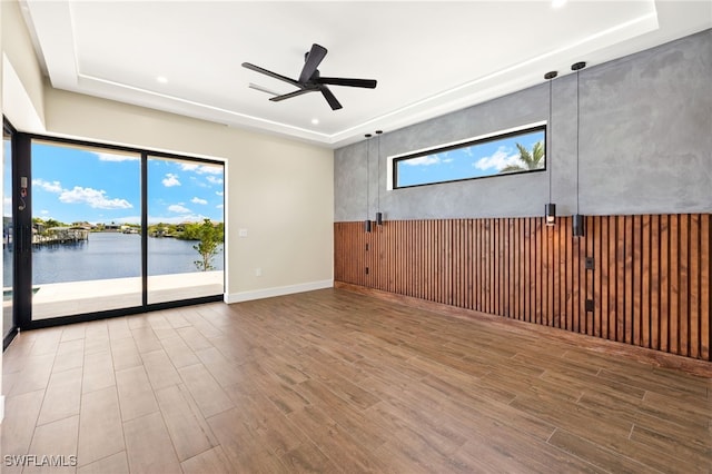 3413 NW 9th Ter, Cape Coral, FL 33993 - unfurnished room with a raised ceiling, wood finished floors, a ceiling fan, recessed lighting, and a water view