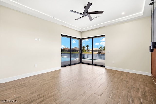3413 NW 9th Ter, Cape Coral, FL 33993 - empty room with baseboards, wood finished floors, ceiling fan, and a water view