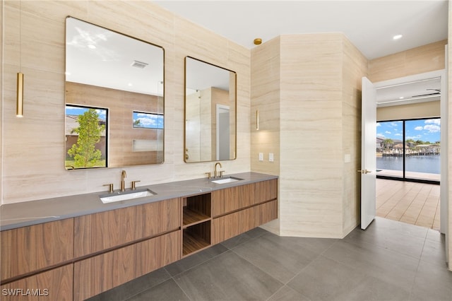 3413 NW 9th Ter, Cape Coral, FL 33993 - full bath featuring double vanity, tile walls, tile patterned flooring, and a water view