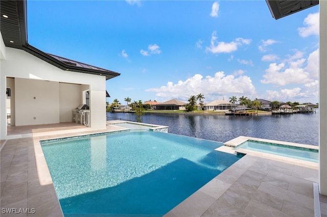3413 NW 9th Ter, Cape Coral, FL 33993 - view of swimming pool with area for grilling, a patio area, a pool with connected hot tub, a water view, and a residential view
