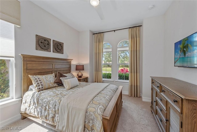 bedroom featuring light colored carpet and baseboards