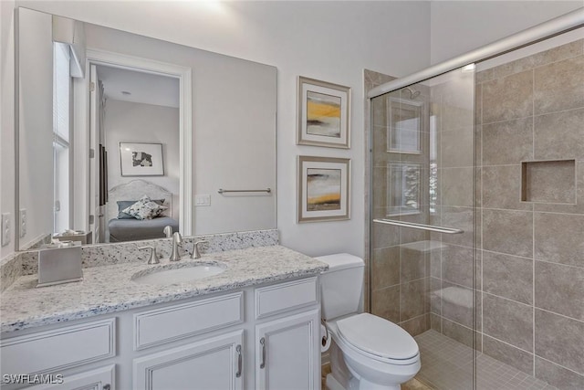 bathroom featuring a shower stall, toilet, ensuite bathroom, and vanity
