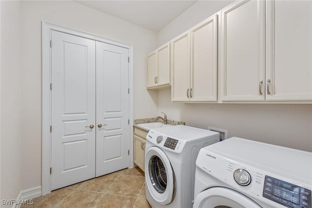 washroom with cabinet space, washer and clothes dryer, light tile patterned floors, and baseboards