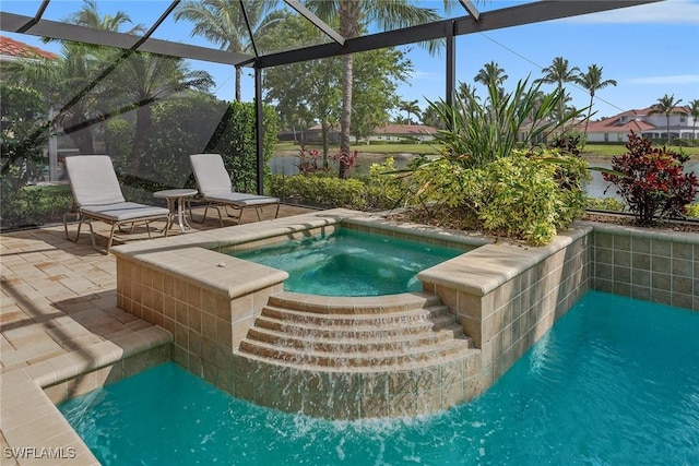 view of pool with an in-ground hot tub, a patio area, and glass enclosure
