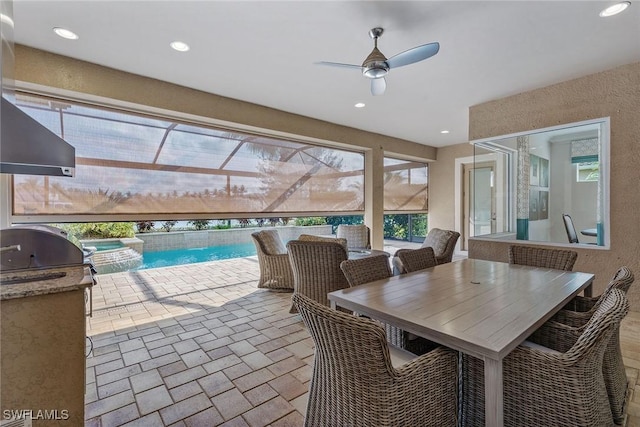 view of patio / terrace with a pool with connected hot tub, an outdoor kitchen, ceiling fan, and area for grilling