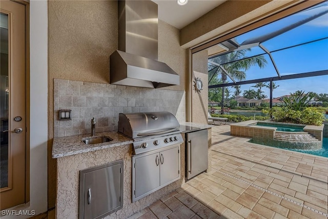 view of patio / terrace featuring a sink, grilling area, an outdoor kitchen, glass enclosure, and a pool with connected hot tub