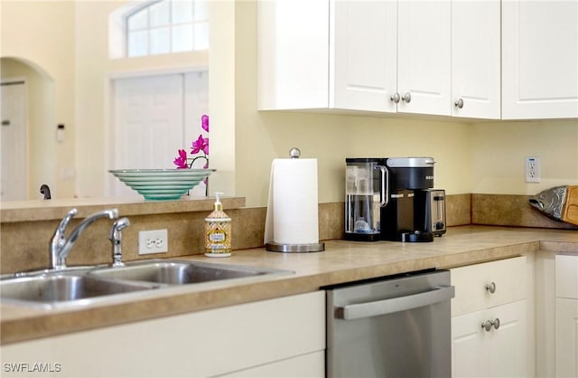 kitchen featuring dishwasher, a sink, white cabinets, and light countertops