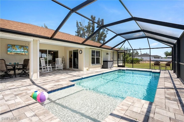 swimming pool featuring a patio and glass enclosure