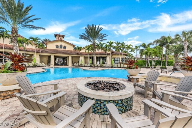 9519 Foxglove Ln, Naples, FL 34120 - community pool featuring an outdoor fire pit and a patio area
