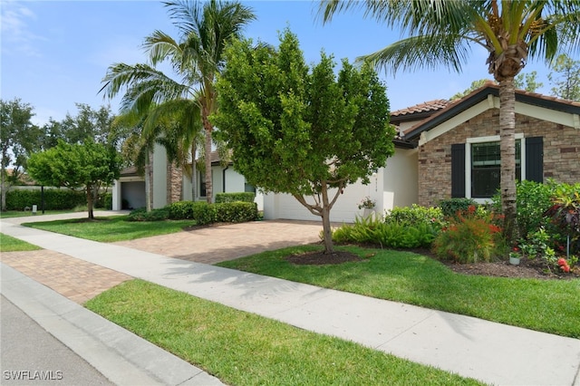 9519 Foxglove Ln, Naples, FL 34120 - view of front facade with decorative driveway, stucco siding, a tiled roof, and a front lawn