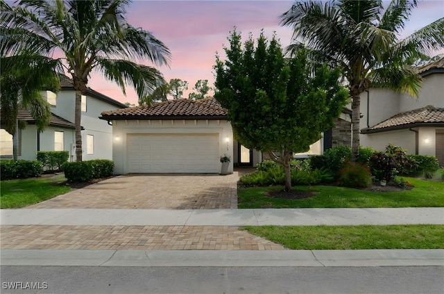 9519 Foxglove Ln, Naples, FL 34120 - mediterranean / spanish home featuring stucco siding, a tile roof, decorative driveway, and an attached garage