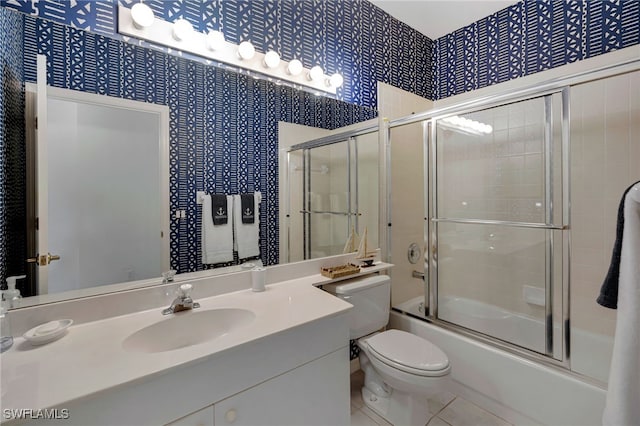 25224 Pelican Creek Cir Unit 203, Bonita Springs, FL 34134 - bathroom with tile patterned floors, toilet, bath / shower combo with glass door, vanity, and wallpapered walls