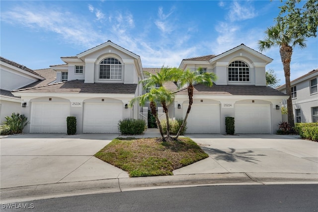 25224 Pelican Creek Cir Unit 203, Bonita Springs, FL 34134 - view of front of home with stucco siding, driveway, and an attached garage