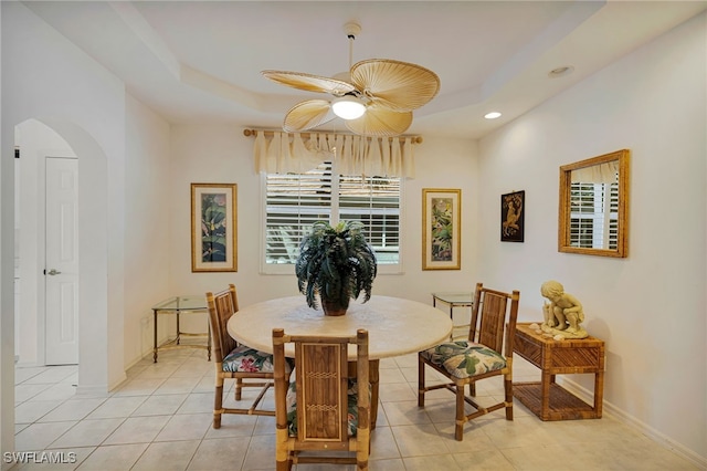 25224 Pelican Creek Cir Unit 203, Bonita Springs, FL 34134 - dining area with arched walkways, a ceiling fan, a tray ceiling, light tile patterned floors, and recessed lighting
