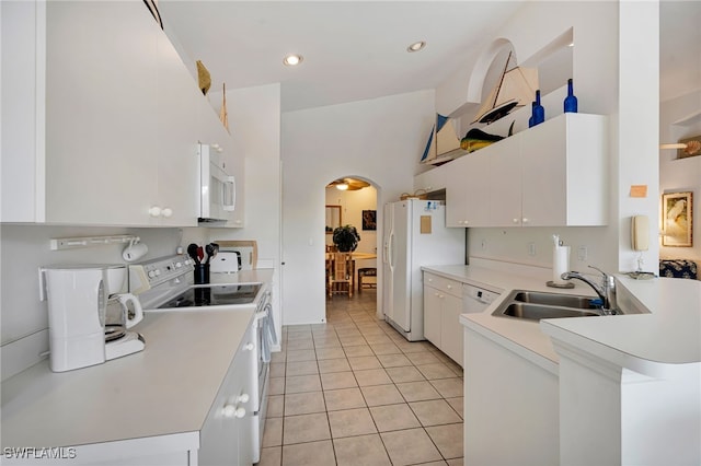 25224 Pelican Creek Cir Unit 203, Bonita Springs, FL 34134 - kitchen featuring white appliances, arched walkways, a sink, light countertops, and light tile patterned floors