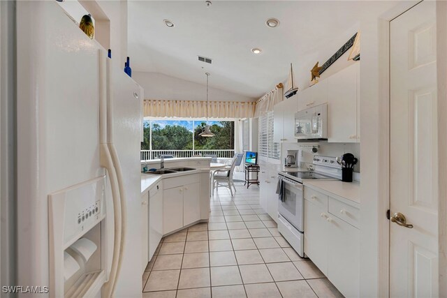 25224 Pelican Creek Cir Unit 203, Bonita Springs, FL 34134 - kitchen featuring white appliances, vaulted ceiling, a sink, light tile patterned floors, and white cabinets