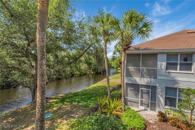 25224 Pelican Creek Cir Unit 203, Bonita Springs, FL 34134 - view of property exterior featuring a water view and a sunroom