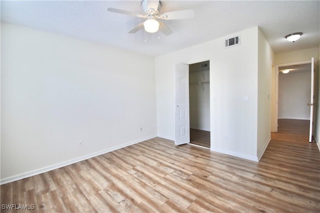 unfurnished bedroom with wood finished floors, baseboards, a closet, a textured ceiling, and ceiling fan