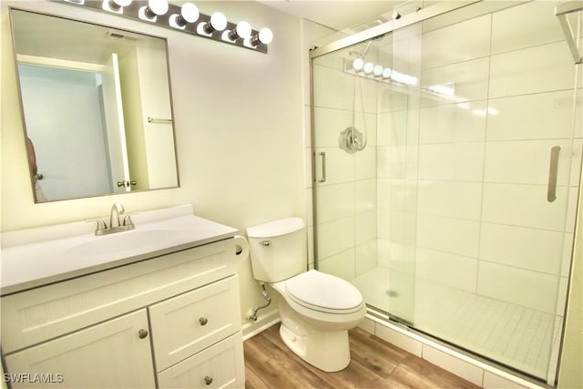 full bath with toilet, wood finished floors, a shower stall, and vanity