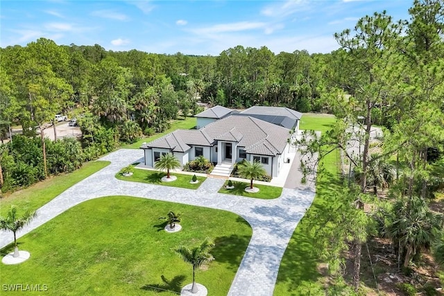 333 12th Ave NE, Naples, FL 34120 - view of front of house with curved driveway, stucco siding, a view of trees, and a front yard