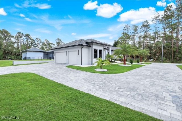 333 12th Ave NE, Naples, FL 34120 - view of front facade featuring decorative driveway, a tile roof, and a garage