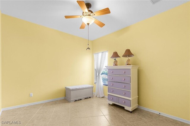 tiled bedroom with baseboards and a ceiling fan