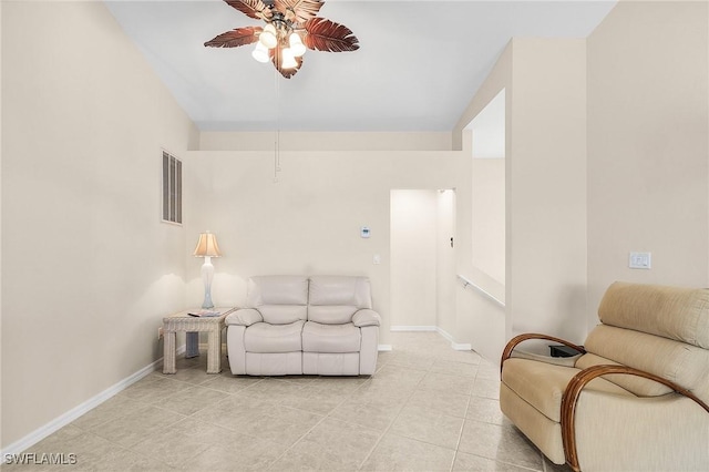 living area featuring a ceiling fan, baseboards, and light tile patterned flooring